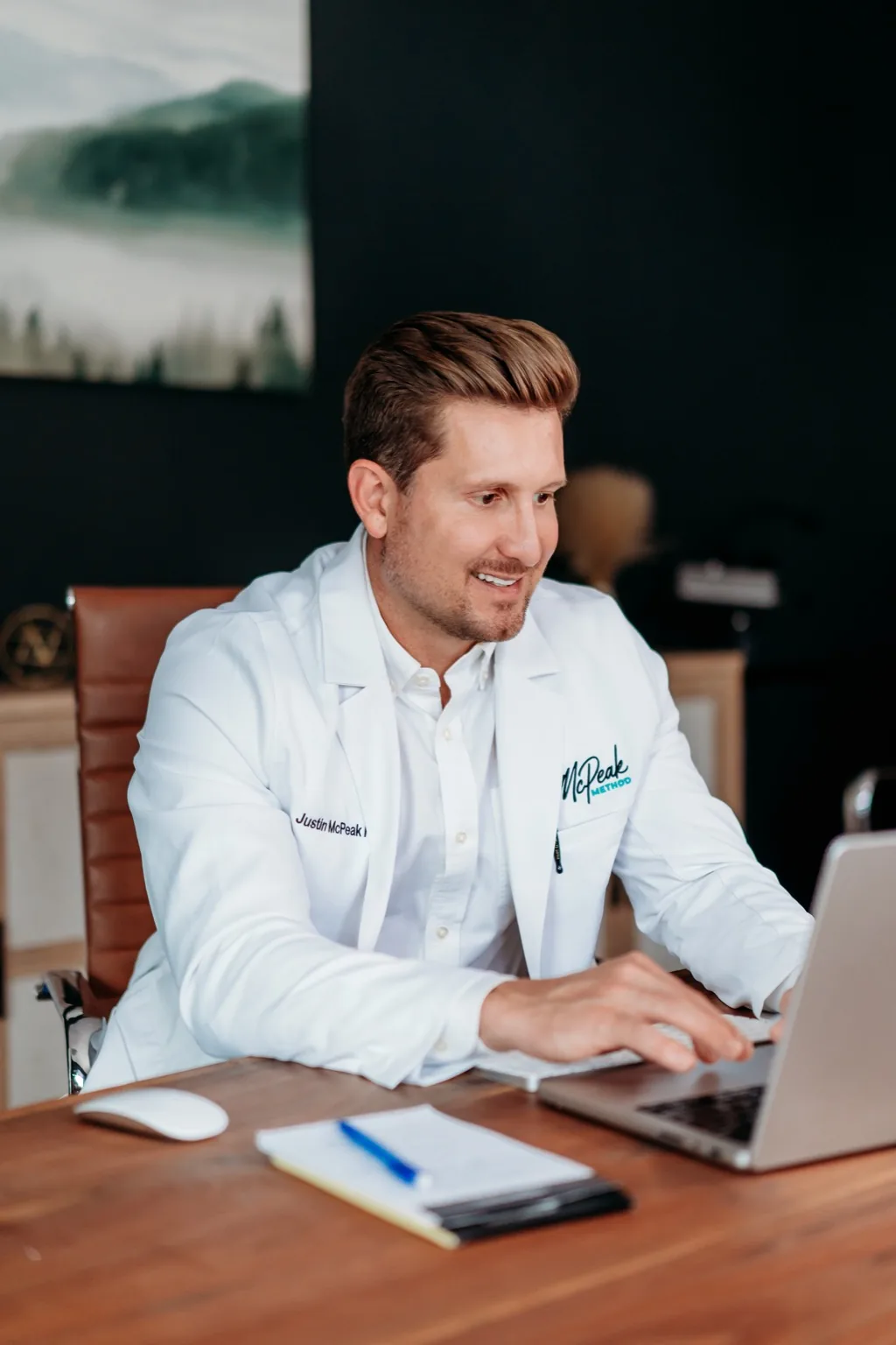 Justin McPeak reviewing patient care at his laptop